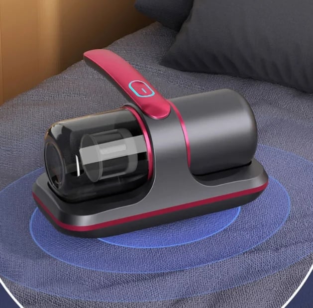 ForKumi allergen vacuum cleaner for dust mites in black and pink on a gray fabric surface