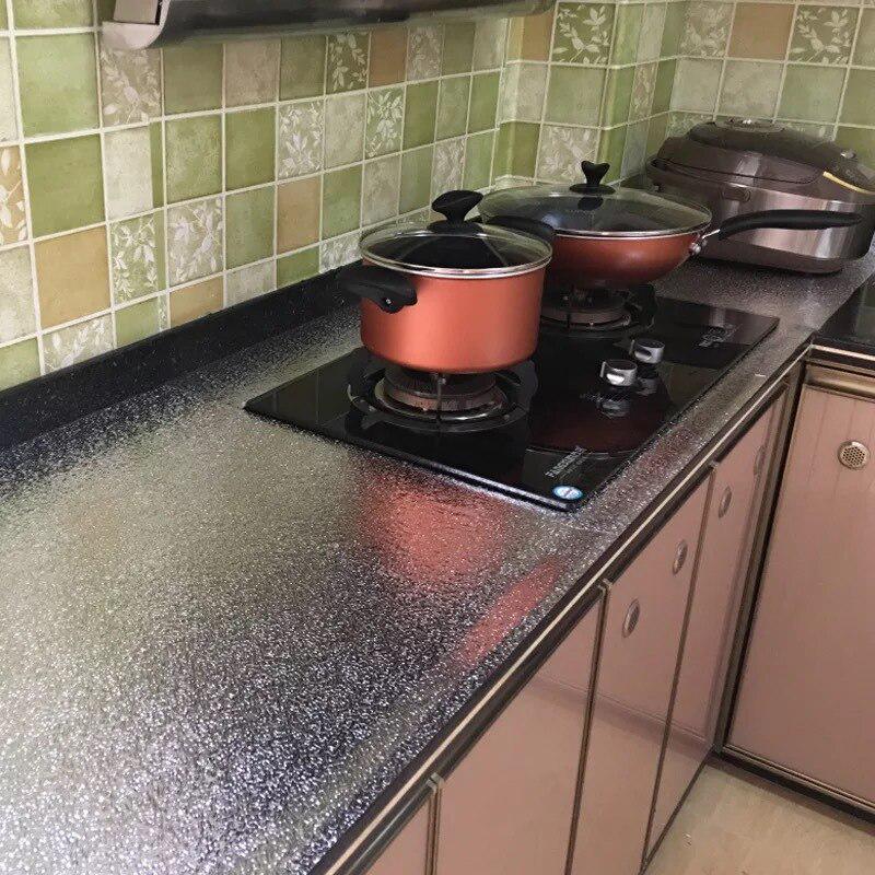 ForKumi aluminum foil kitchen sticker applied on kitchen countertop behind stove with cookware