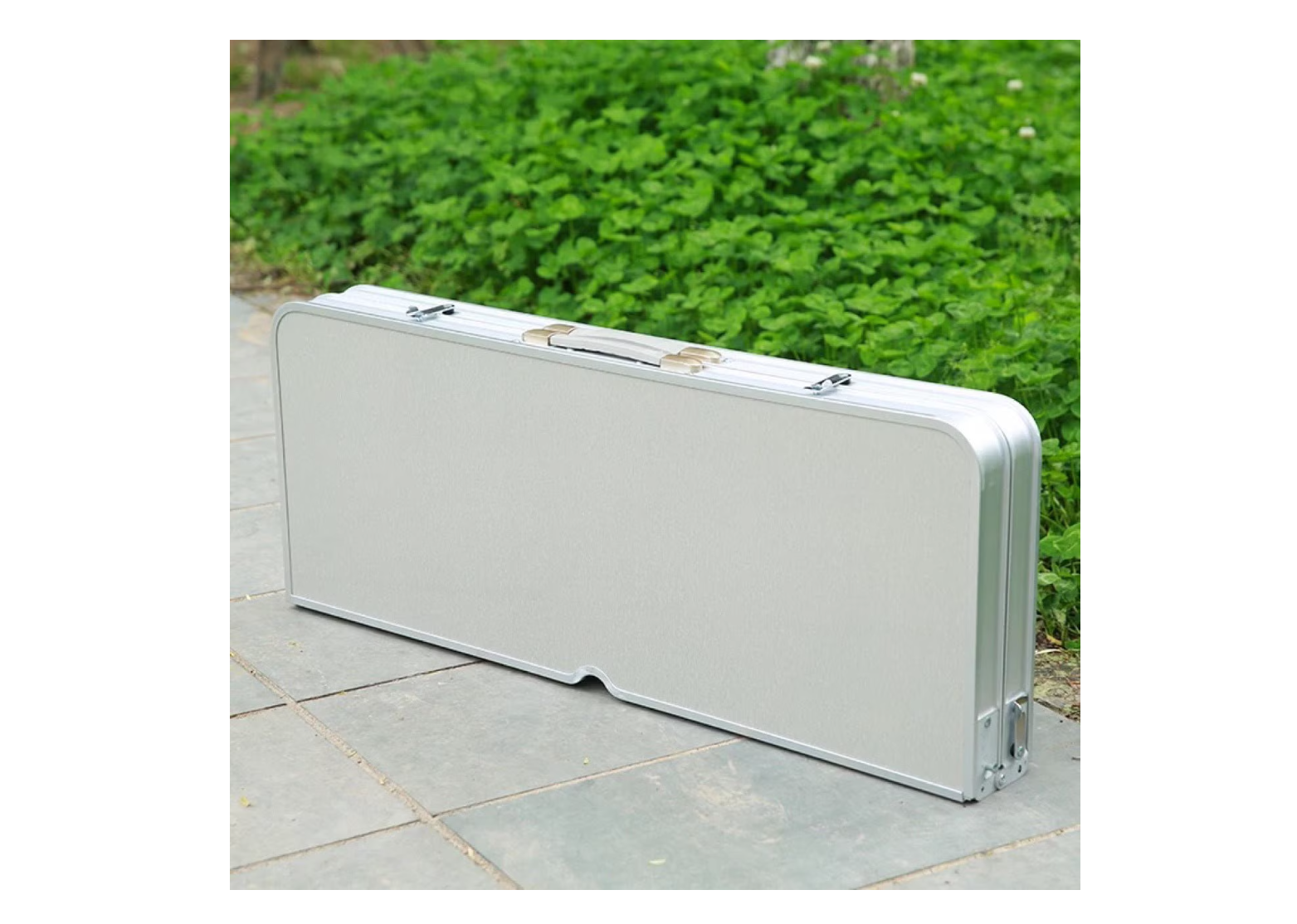 ForKumi folding patio table set compactly folded inside a silver carrying case on outdoor pavement