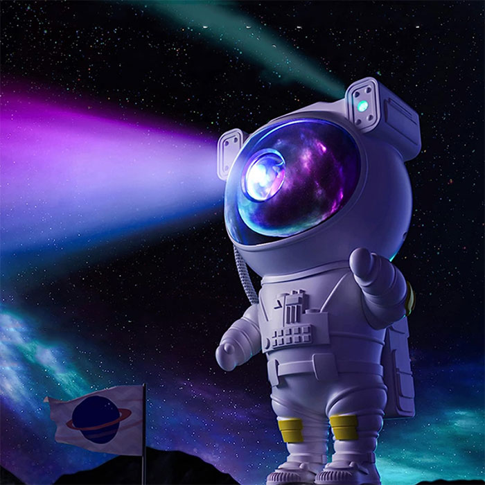 ForKumi astronaut galaxy projector night light casting colorful cosmic beams in a space setting
