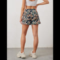 Avis camo elastic waist shorts worn by woman from the back with white crop top and sneakers