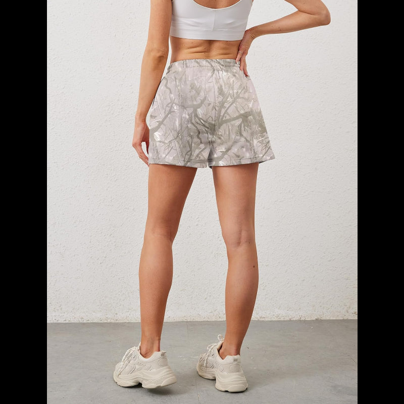 Avis camo elastic waist shorts in light gray camouflage pattern worn by woman with white sports bra and sneakers