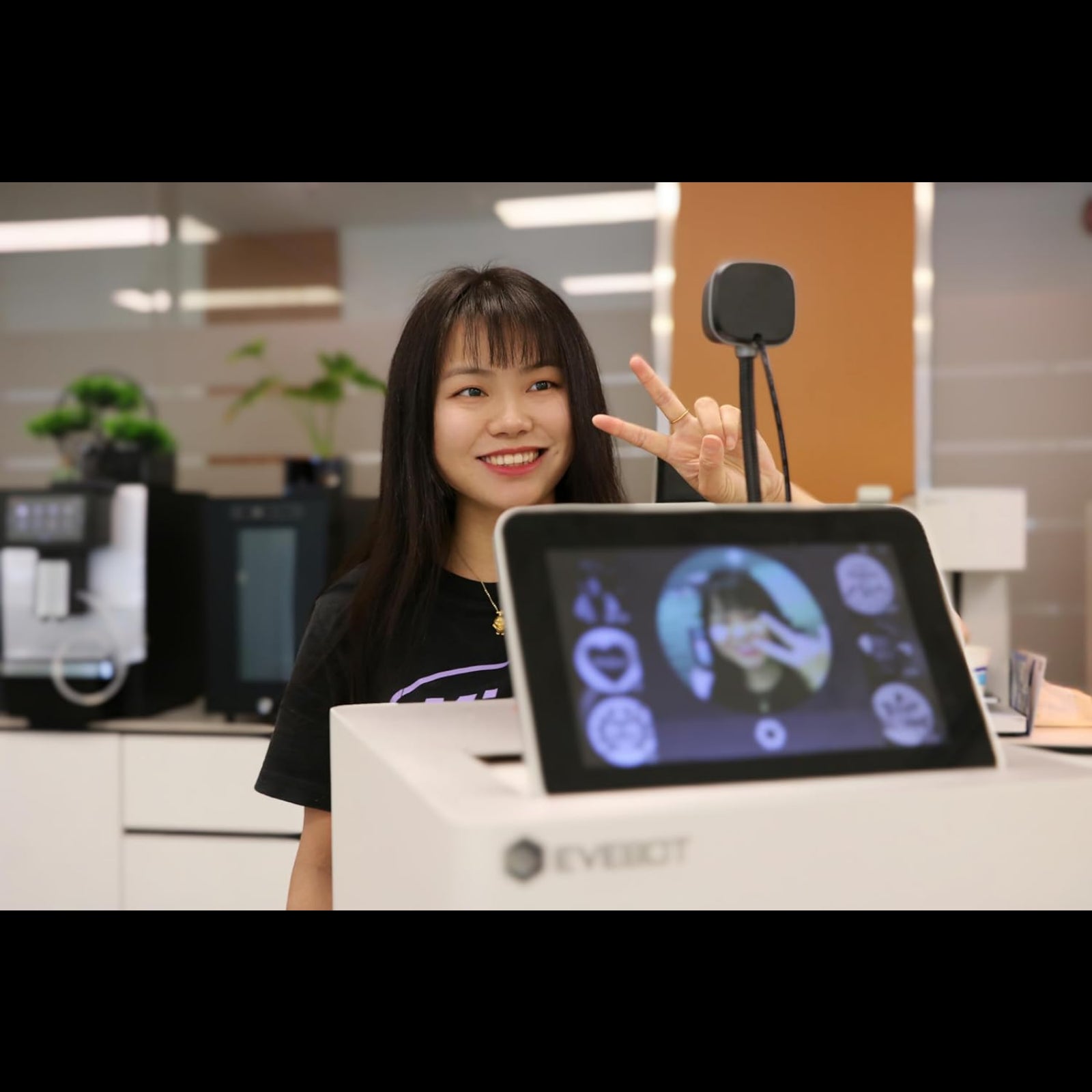 Young woman using a custom coffee art printer from My Store with touchscreen display and camera setup