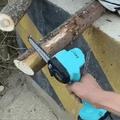 ForKumi 6 inch cordless chainsaw kit cutting a small tree branch outdoors