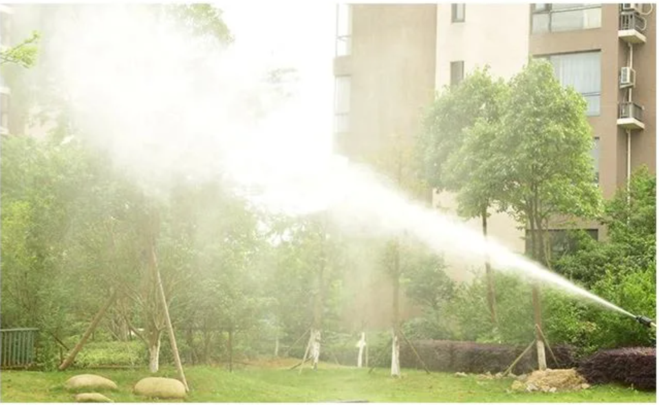ForKumi 1400W electric pressure washer spraying water in a garden near residential buildings