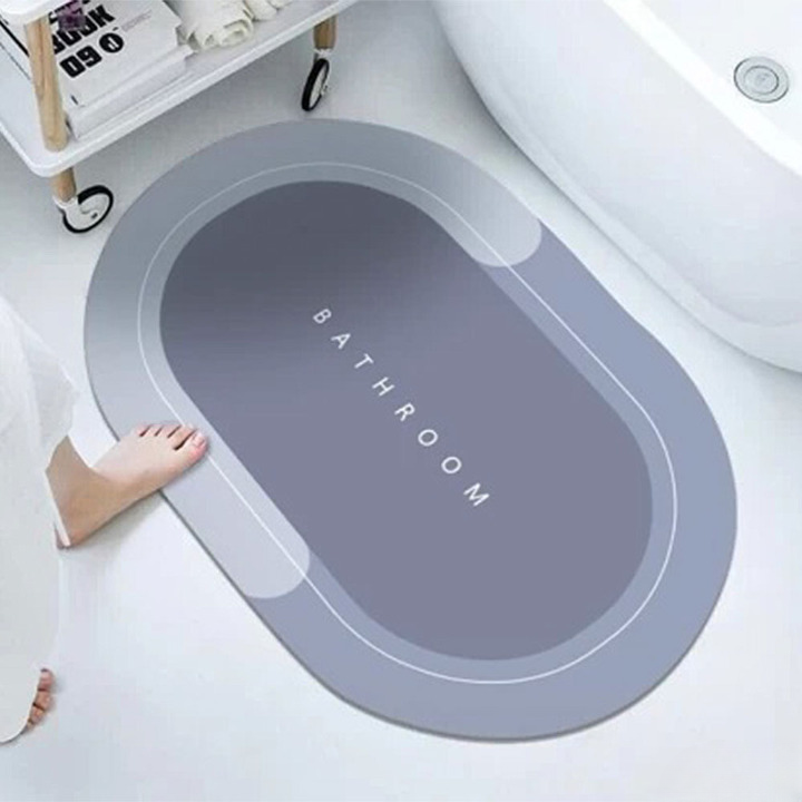 ForKumi quick dry bath mat in gray with bathroom text placed beside bathtub on white floor