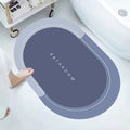 ForKumi quick dry bath mat in gray blue with oval shape placed next to bathtub on white bathroom floor