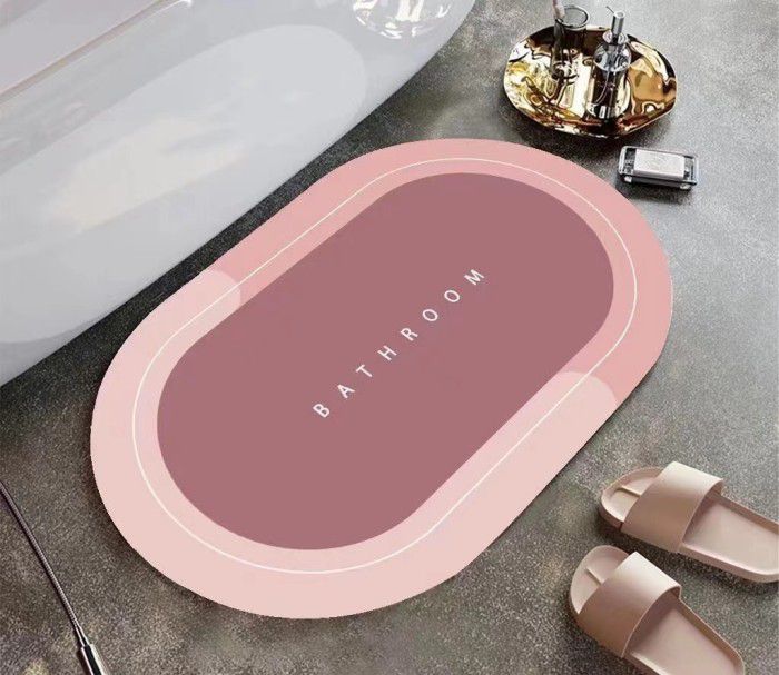 ForKumi quick dry bath mat in pink with bathroom text placed beside bathtub and slippers