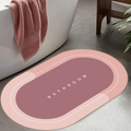 ForKumi quick dry bath mat in pink and mauve with bathroom text placed beside bathtub