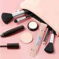 ForKumi 2-in-1 hair remover for women next to makeup brushes and cosmetic products on pink background