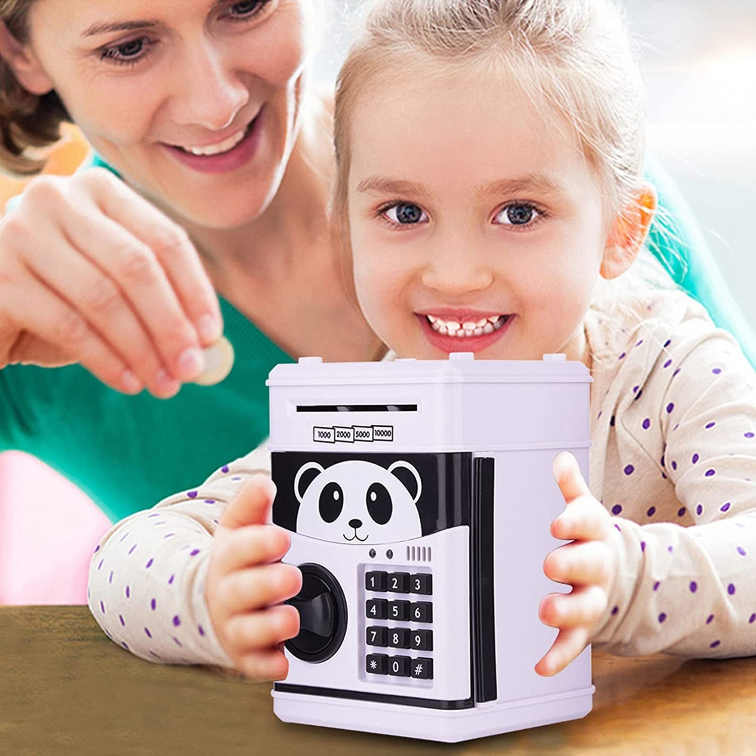 Child holding a ForKumi kids ATM piggy bank with panda design while parent inserts a coin