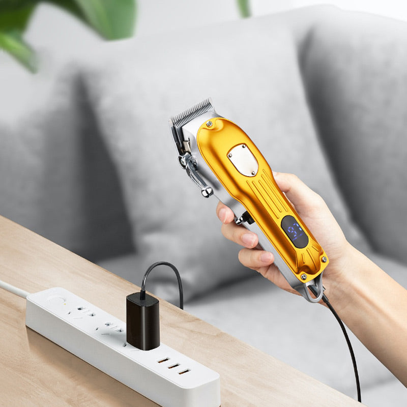 ForKumi LCD hair clipper for men in gold held over wooden table with charger plugged in