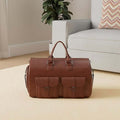 ForKumi 40L men's duffle bag in brown leather with front pockets placed on living room floor