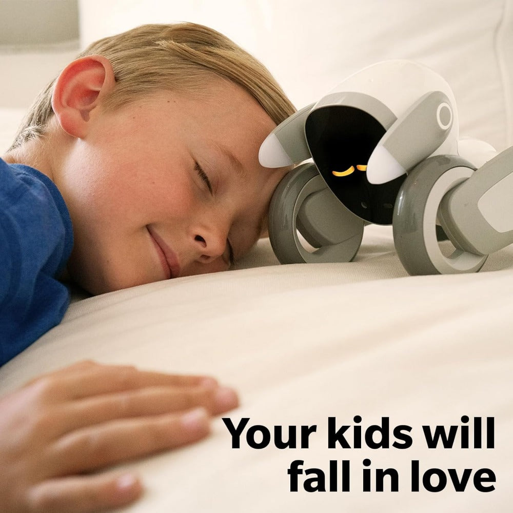 Child resting next to Loona AI robot pet on bed showing interactive AI toy for kids