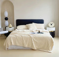 ForKumi luxury reversible bed blanket in cream color on a modern bed with matching pillows