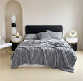 Luxury reversible bed blanket in soft gray with matching pillows on modern bed by ForKumi