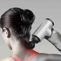 ForKumi mini percussion massage gun being used on the neck to relieve muscle tension