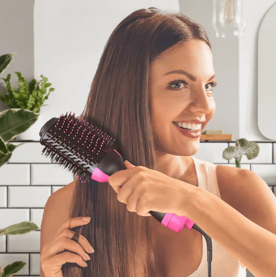 Woman using ForKumi 1000W hot air brush styler to smooth and style long straight hair in bathroom
