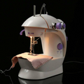 ForKumi portable 4-in-1 sewing machine in white with purple knobs stitching fabric