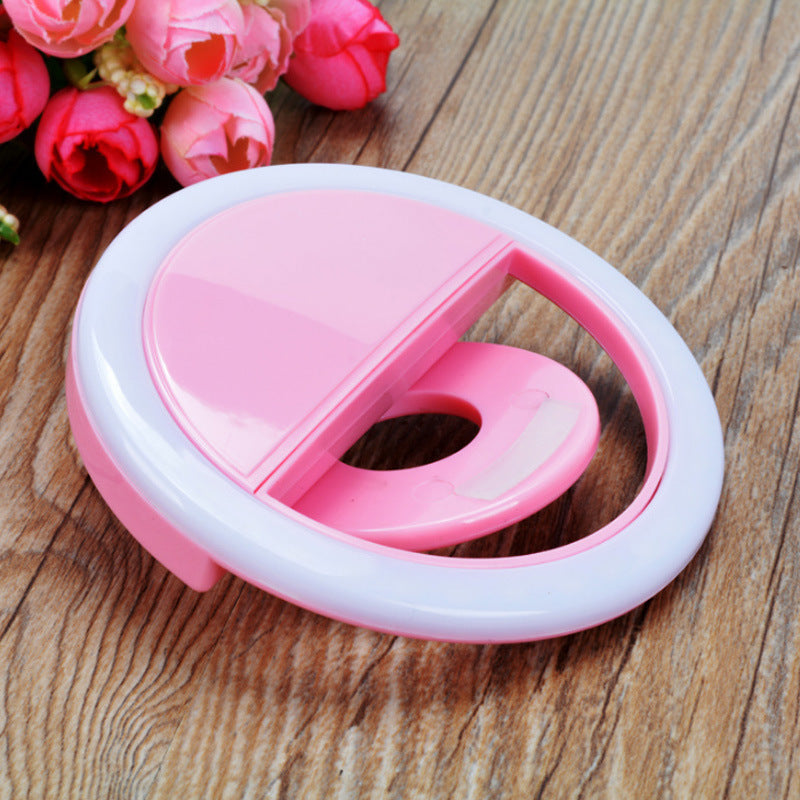 ForKumi pink pro selfie ring light with clip on wood surface and pink flowers background
