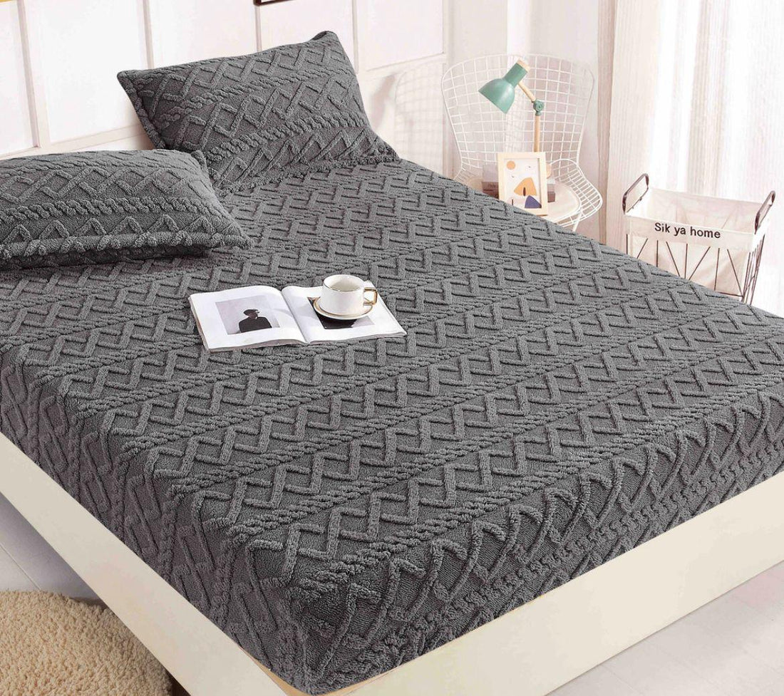 Soft chenille fitted bed cover in brown with textured geometric pattern on a beige upholstered bed