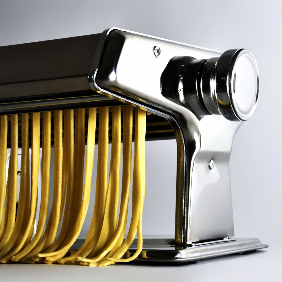 ForKumi stainless steel pasta maker with fresh pasta noodles being rolled out