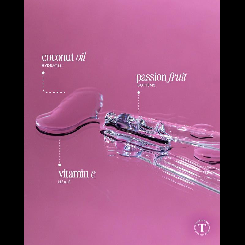 Close-up of men's post-shave serum with coconut oil, passion fruit, and vitamin E on pink surface