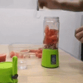 ForKumi green USB portable blender blending fresh watermelon pieces on kitchen counter