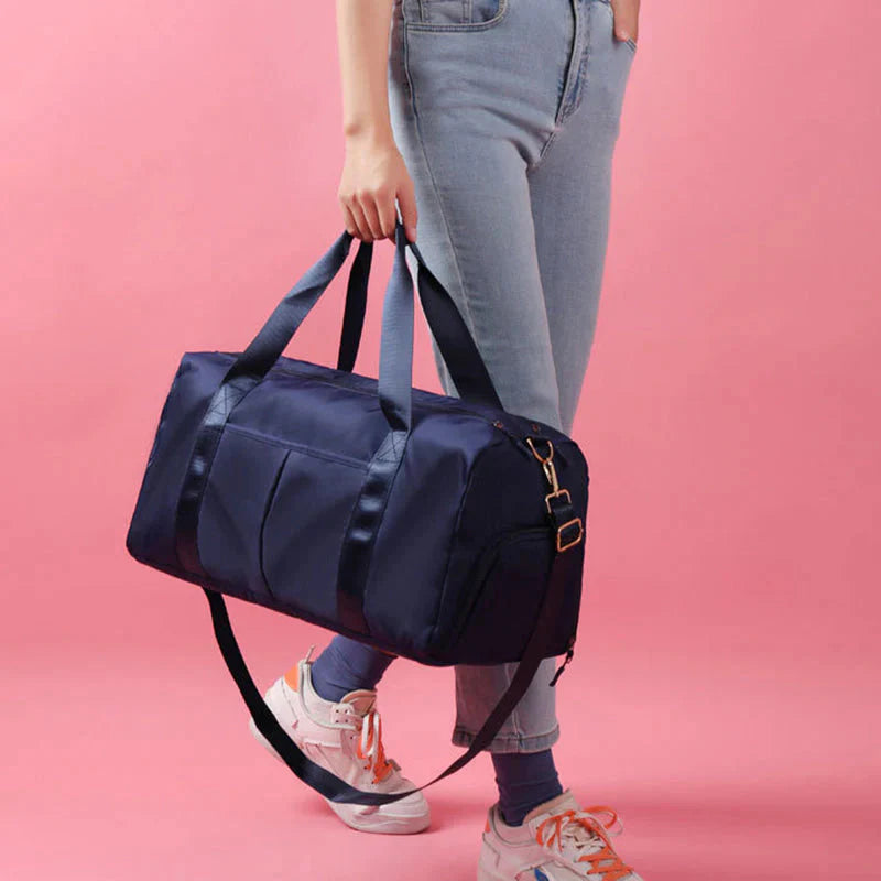 ForKumi waterproof gym duffel bag in navy blue carried by person with jeans and sneakers