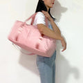 ForKumi waterproof gym duffel bag in pink carried over shoulder by woman in casual outfit