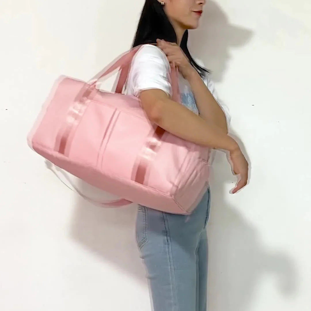 ForKumi waterproof gym duffel bag in pink carried over shoulder by woman in casual outfit
