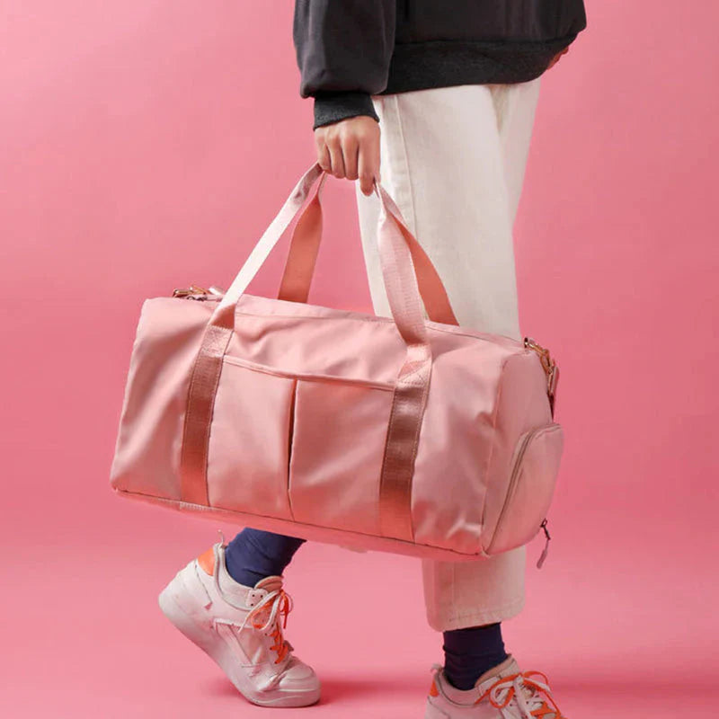 ForKumi pink waterproof gym duffel bag held by person wearing white pants and sneakers