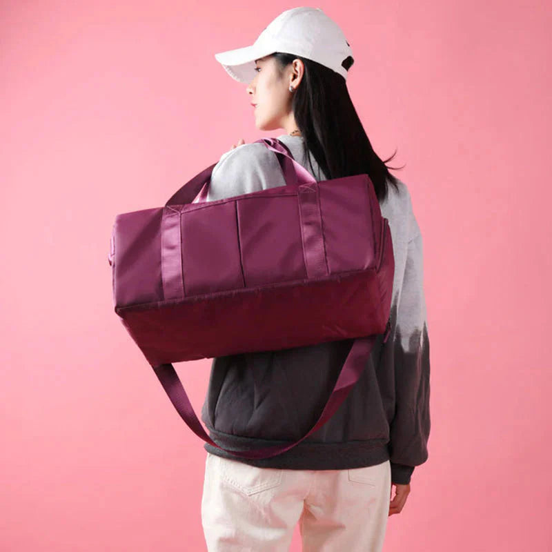 ForKumi waterproof gym duffel bag in purple carried by woman with white cap and gray sweatshirt