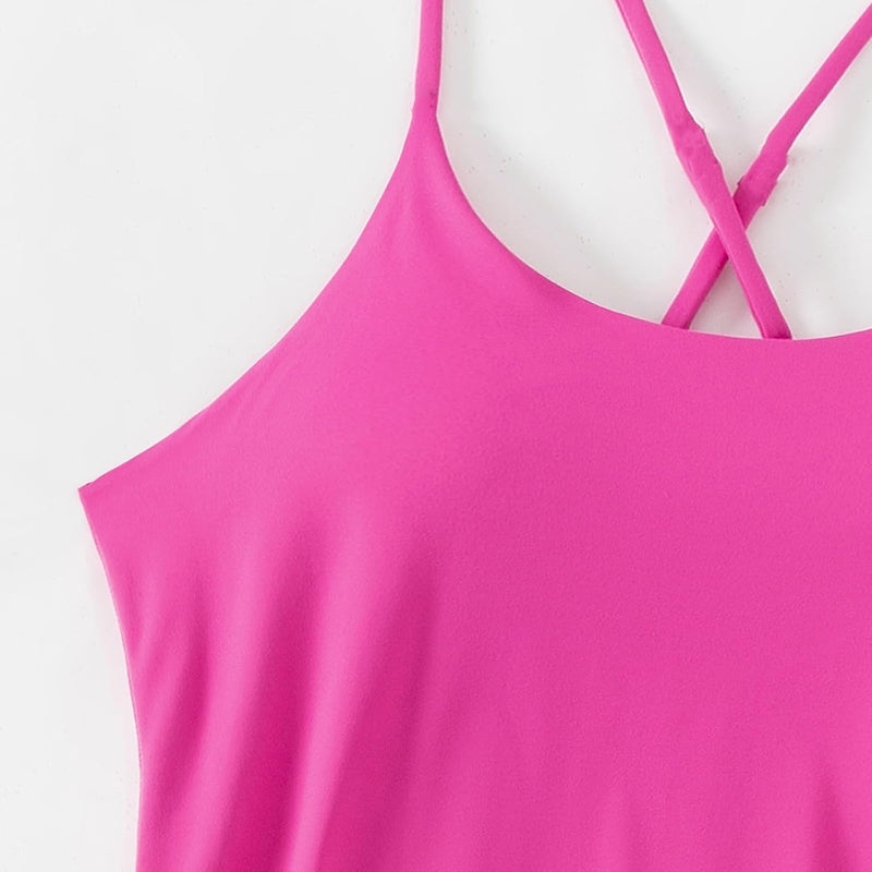Close-up of bright pink women's active dress by Avis with thin crossed shoulder straps